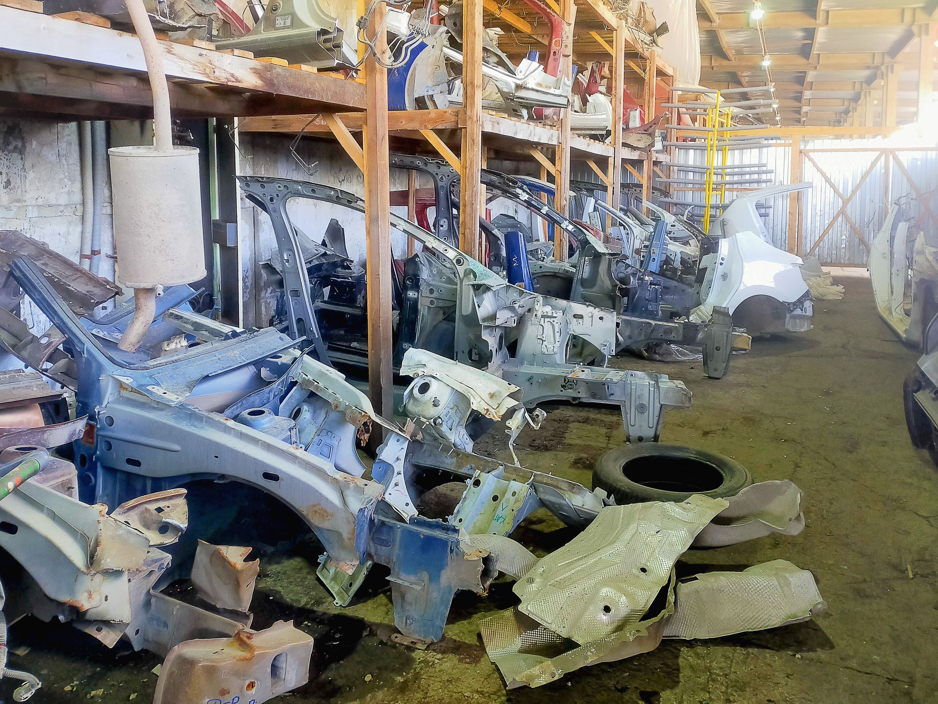 Remains of dismantled bodies of post-accident cars. Spare parts for body repair work on car restoration. Business of dismantling broken cars for workable spare parts.