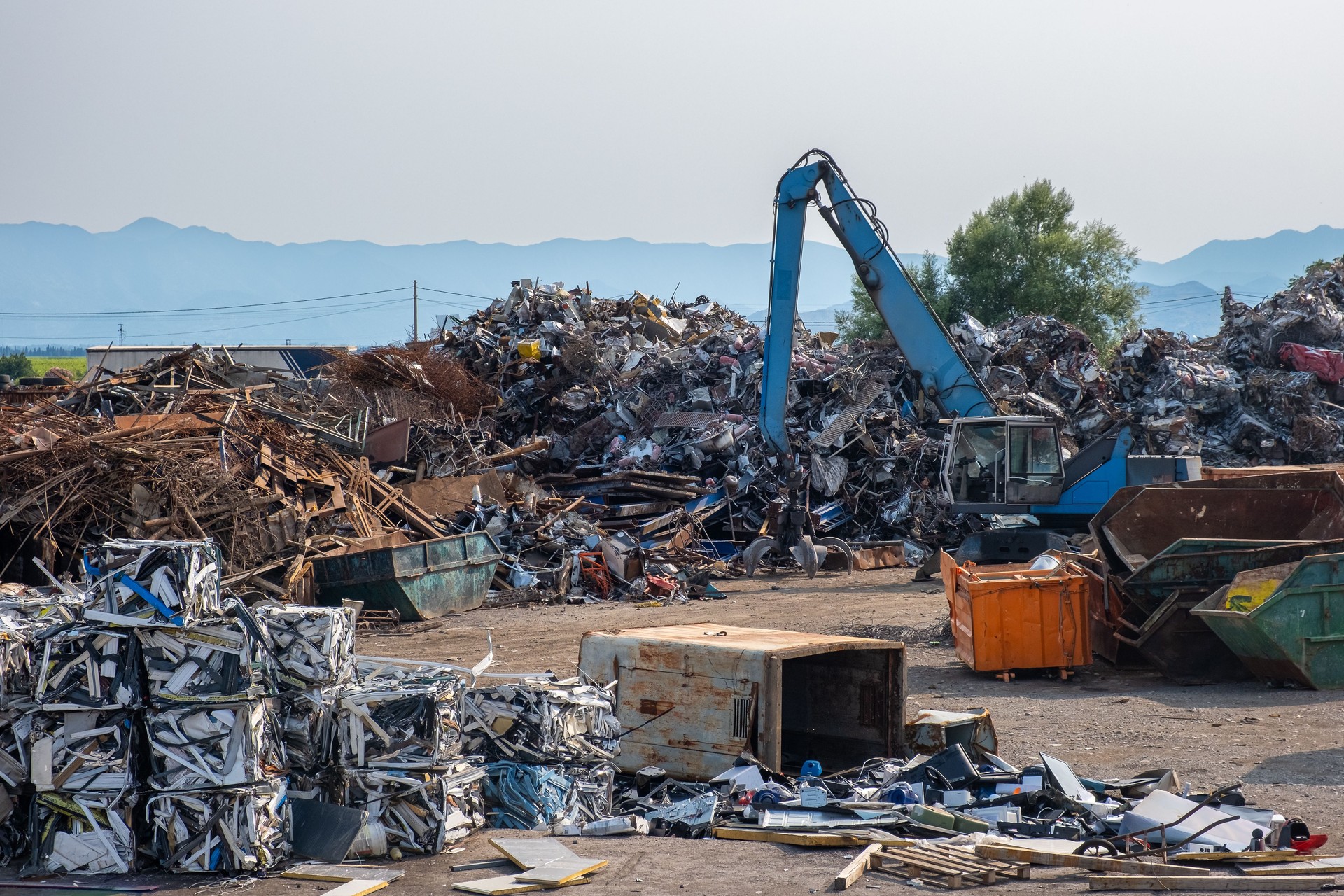 Clow crane picking up scrap metal at recycling center for metal, aluminum, brass, copper, stainless steel in junk yard. Recycling industry. Environment, Earth day and zero waste concept